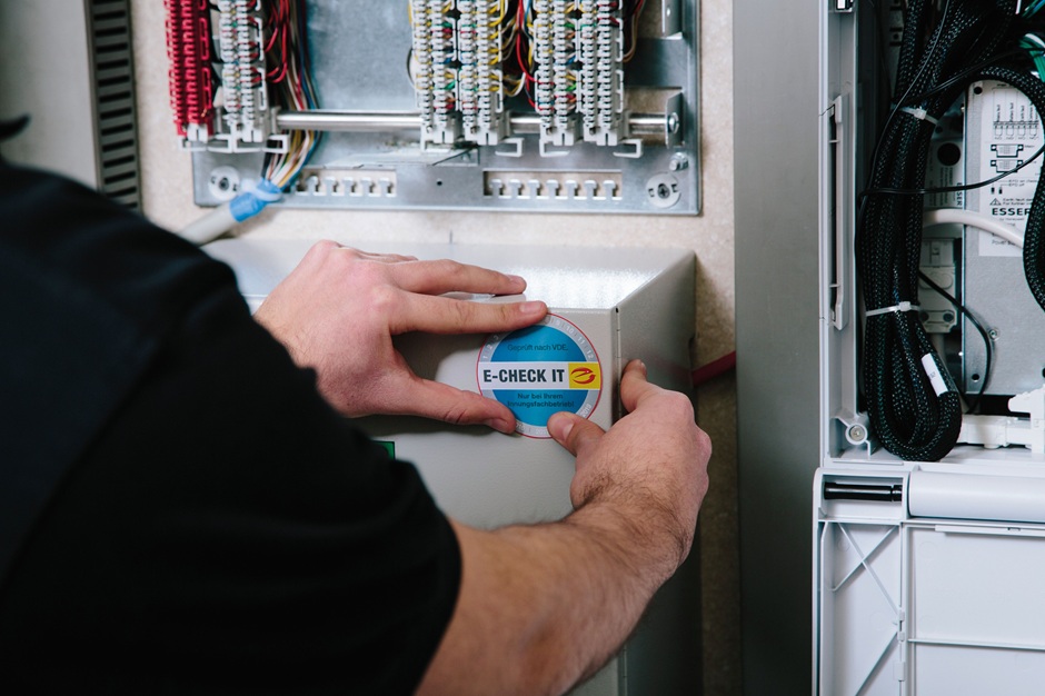 Verkleben der E-Check IT-Plakette nach Prüfung der Anage.