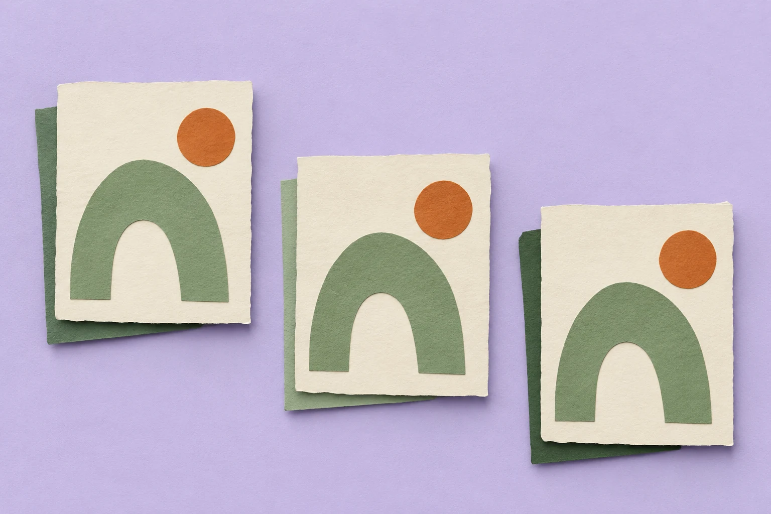 Three cream paper cards repeat the same green arch and orange circle on a pale lavender background.