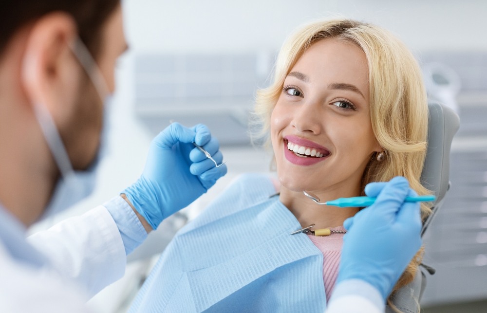 Graphic titled “Dental Billing Glossary” with an open book illustration at the bottom and the Wisdom logo at the top, set against a light teal background framed in dark teal.