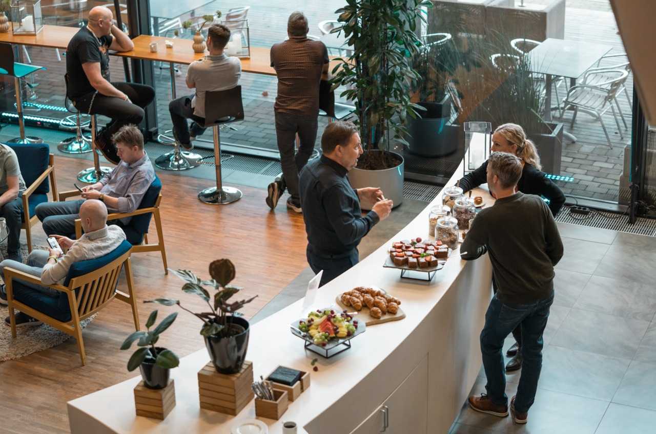 En gruppe mennesker snakker i en spisesal