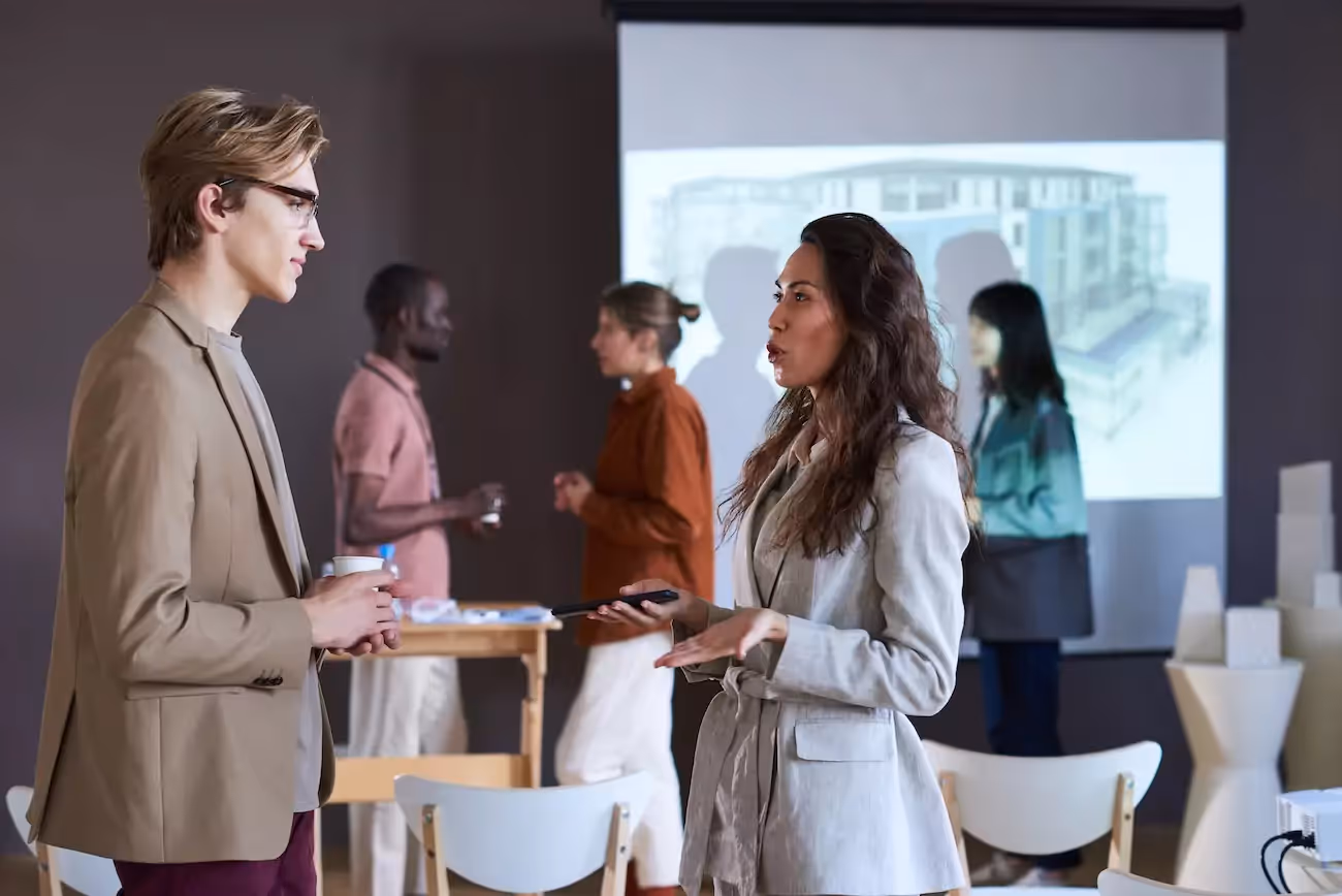 Two people having a conversation at corporate networking event .