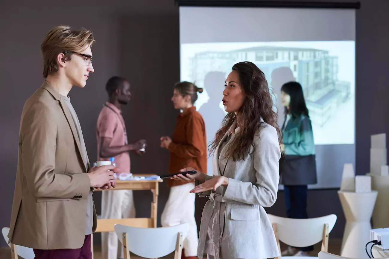 Two people having a conversation at corporate networking event .