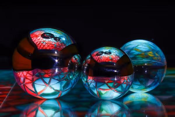 Trois sphères colorées et interconnectées sur fond noir symbolisant la diversité, l’innovation et l’évolution des entreprises de toutes tailles, des startups aux ETI.