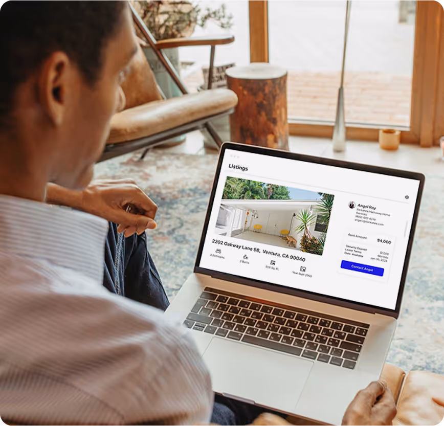 man sitting with laptop displaying listing page.