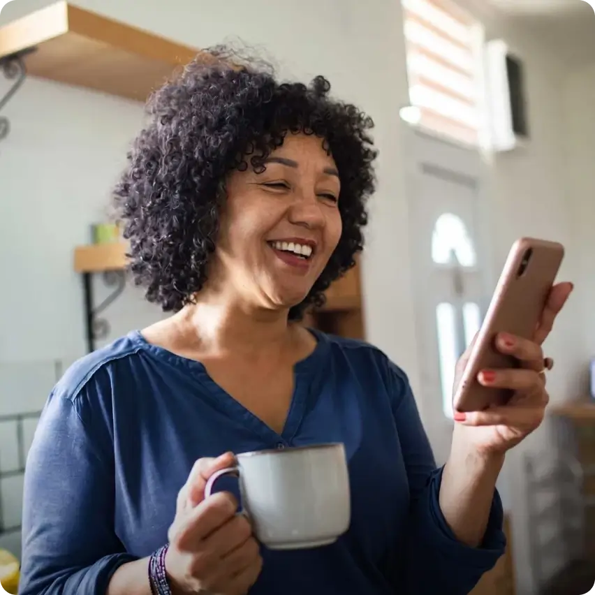 Landlord smiling at her phone while reviewing rental reports