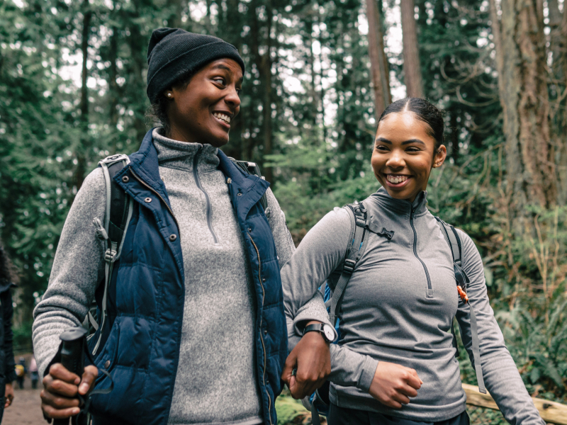Zwei Menschen beim gemeinsamen Spaziergang im Wald