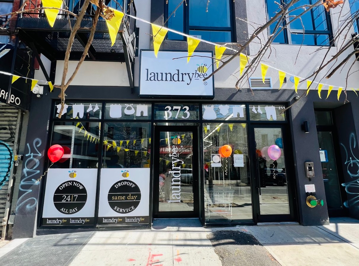 LaundryBee Bushwick storefront at 373 with yellow bunting and balloons