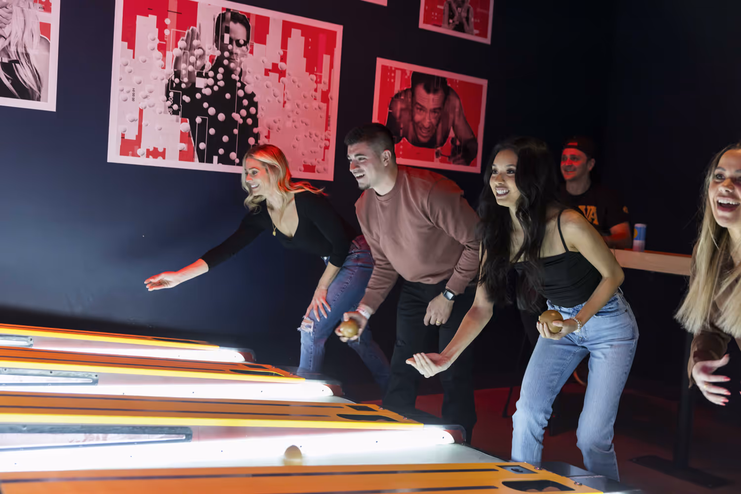 4 people playing skeeball
