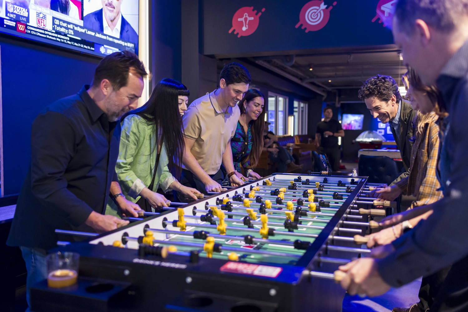 group playing double foosball