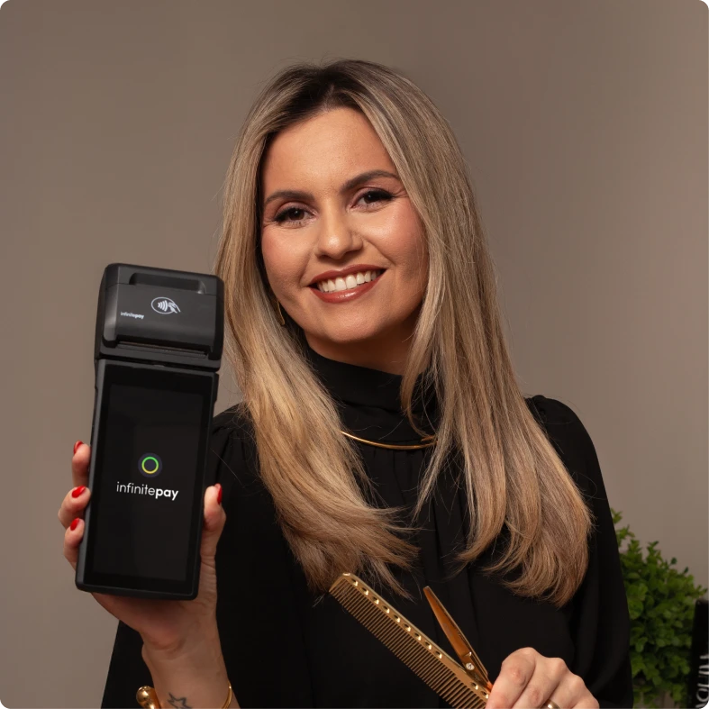 Maquininha de cartão InfinitePay em destaque, iluminada por um feixe de luz, cercada por pedras douradas e escuras em um fundo escuro.