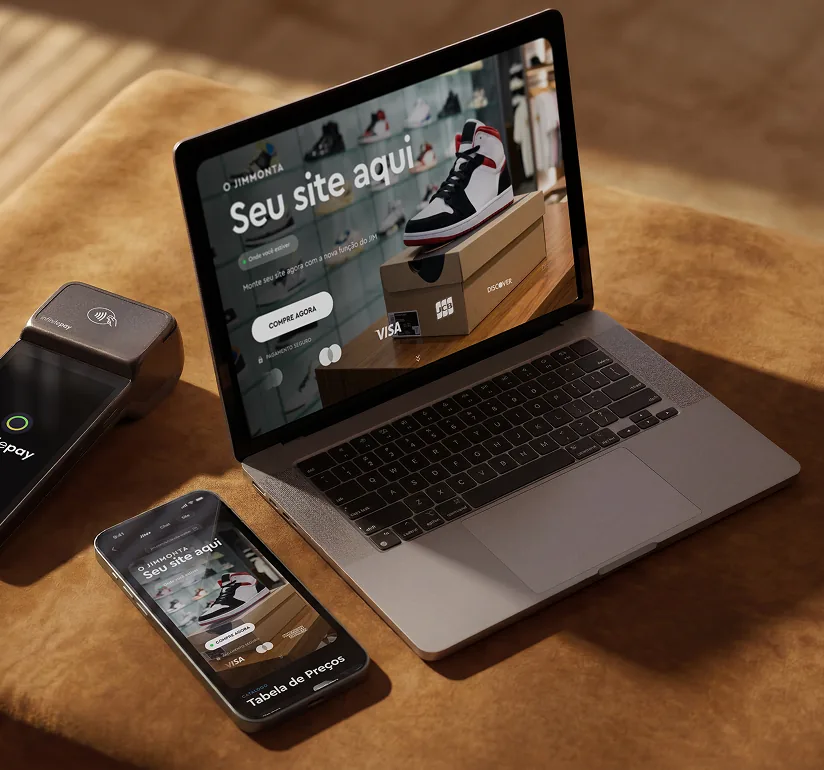 Notebook e celular abertos no mesmo site criado pelo Jim, ao lado da maquininha InfinitePay