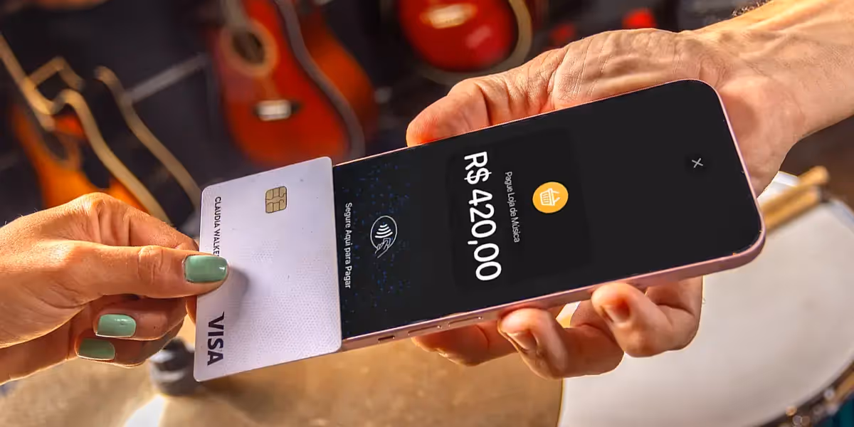 Maquininha de cartão grátis: imagem mostra mão aproximando cartão de crédito de um smartphone com InfiniteTap ativado.