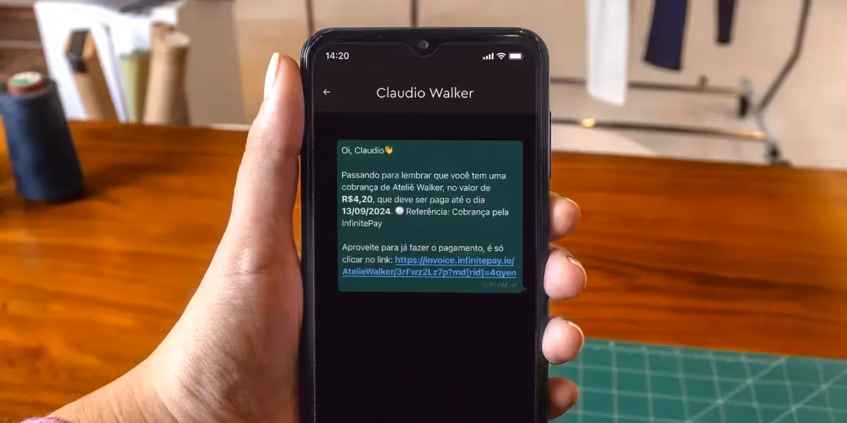 Mão segurando um celular, cuja tela mostra uma mensagem de cobrança, ilustrando uma forma de usar script de cobrança.