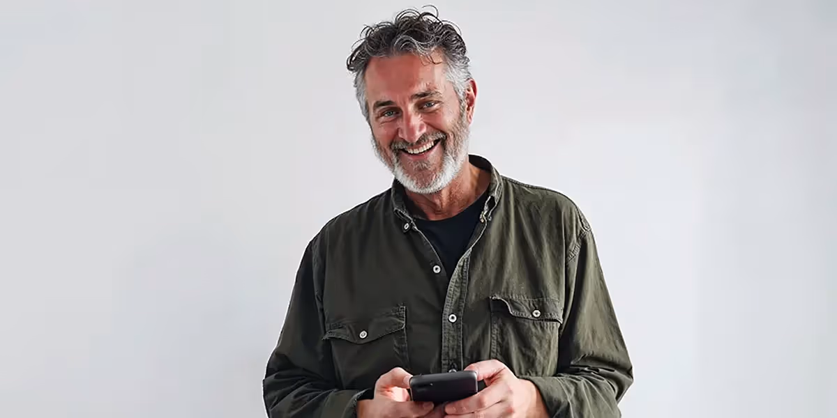 homem com seu celular na mão, pesquisando sobre como usar dois whatsapp no mesmo celular.