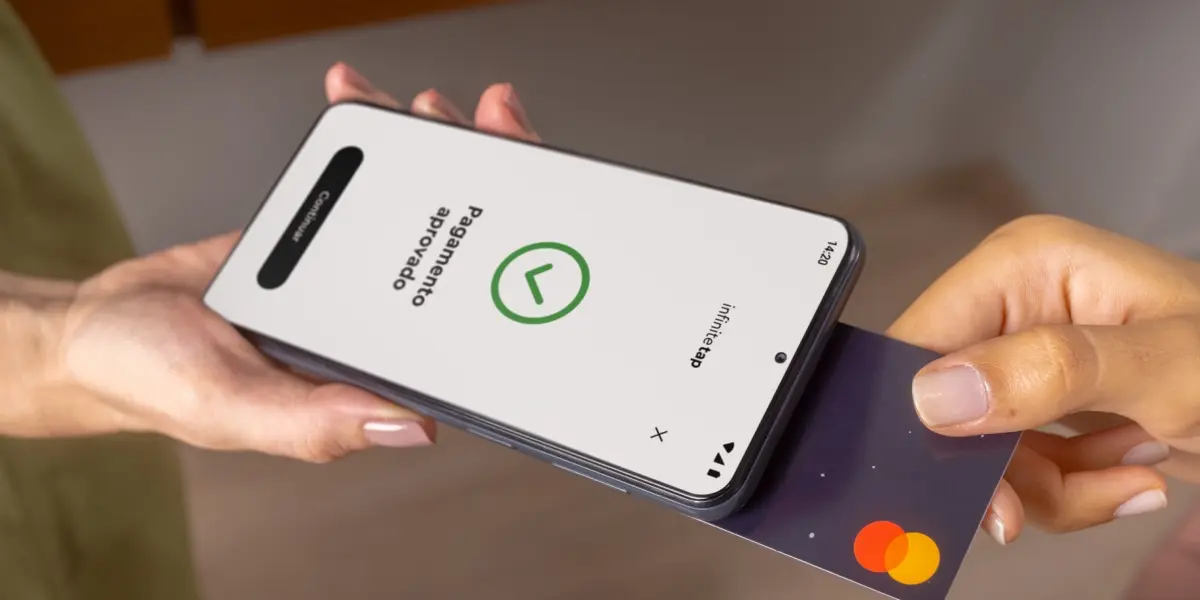 Maquininha no celular menor taxa com pagamento por aproximação aprovado em smartphone segurado por vendedor.