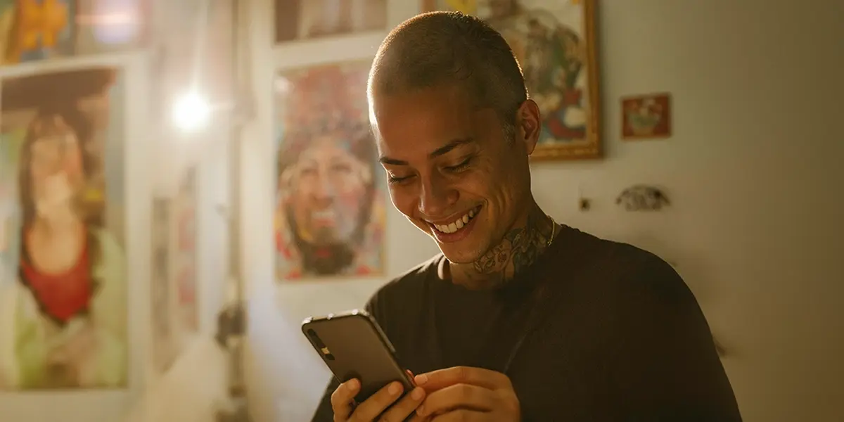 uma mulher em uma ambiente residencial, segunrando um celular olhando para tela indicando estar lendo sobre melhor horario para postar no instagram