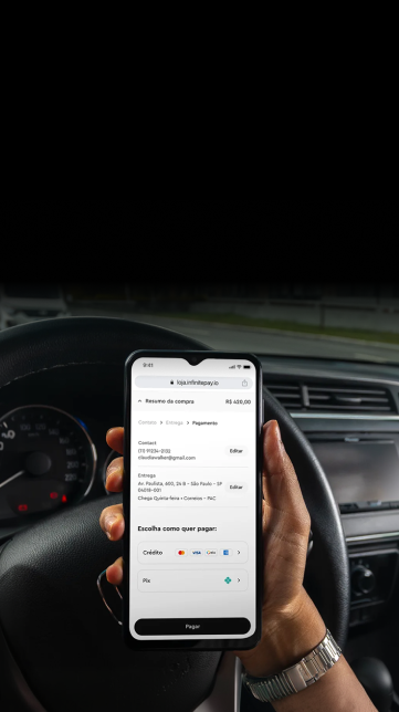 Hand holding phone showing checkout screen with payment options inside a car.