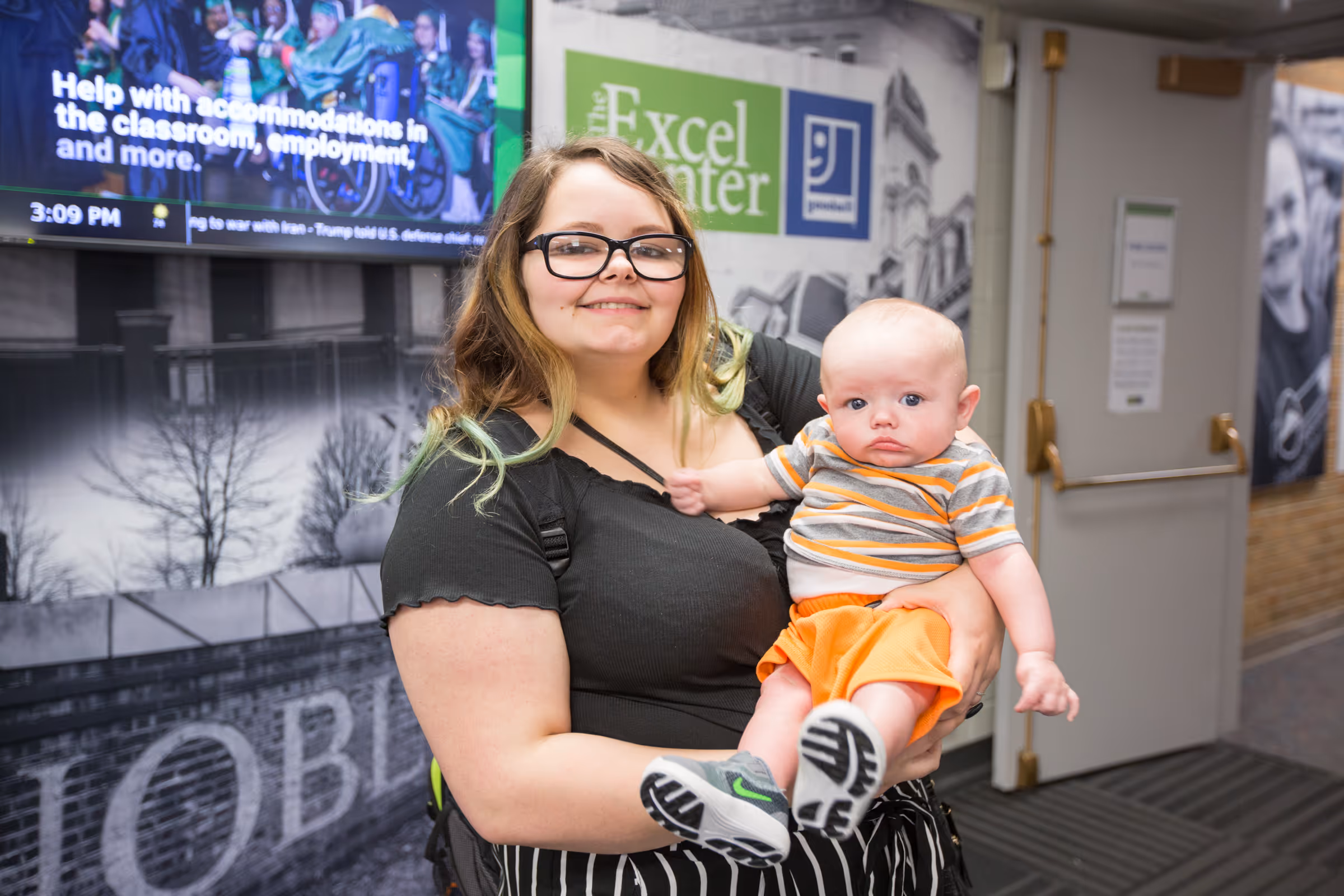 A female Goodwill Excel Center student with her baby