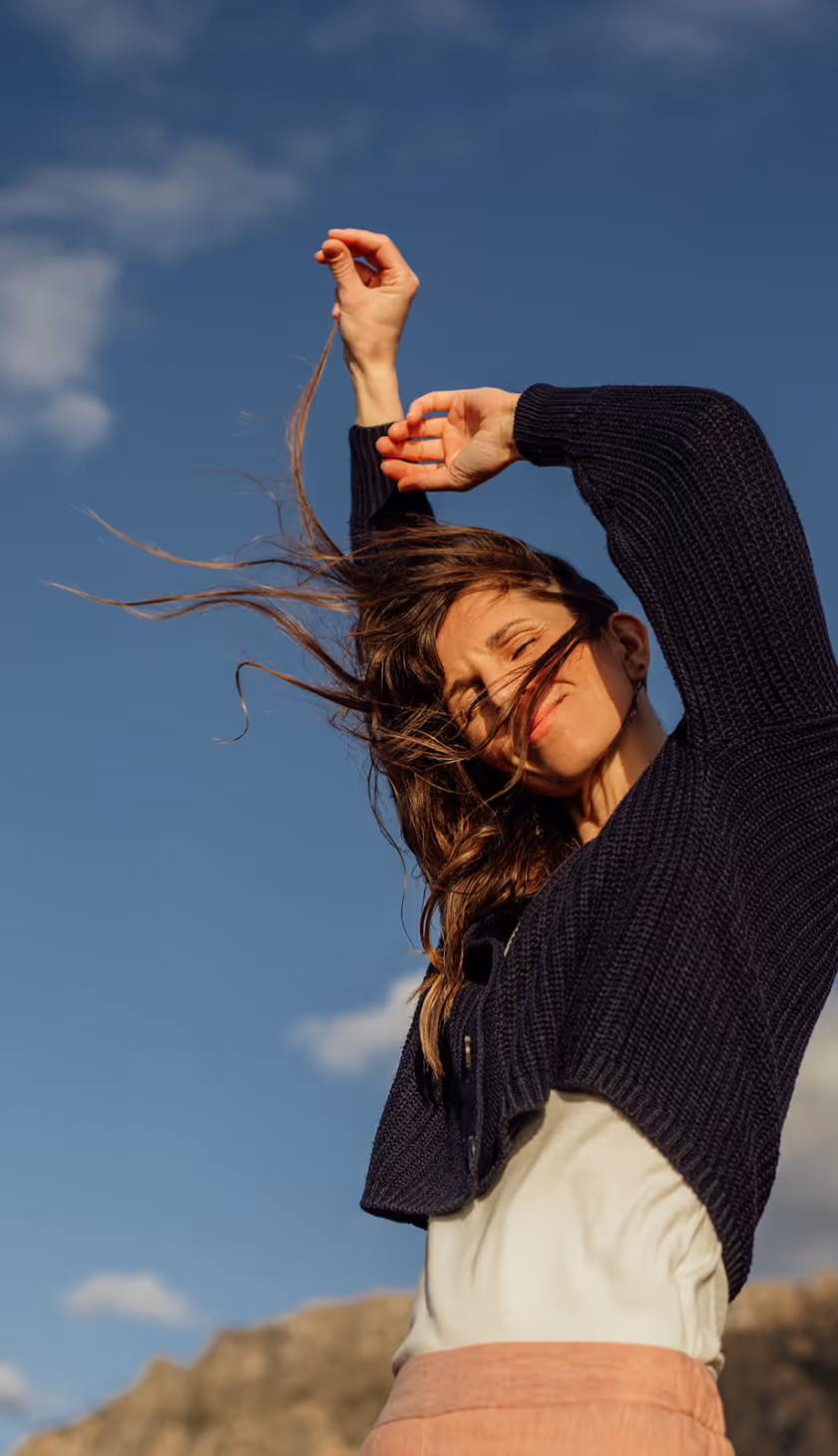 Julie Breiert, Founder of SomaSoul sitting on a beach