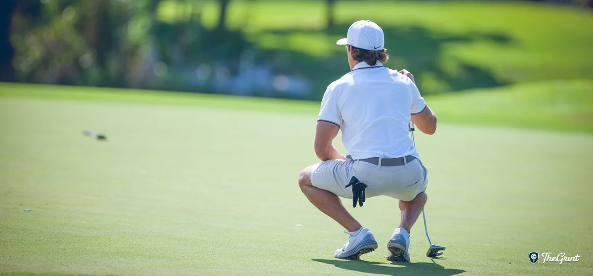 Golfer crouching to read a putt, TheGrint logo in the corner