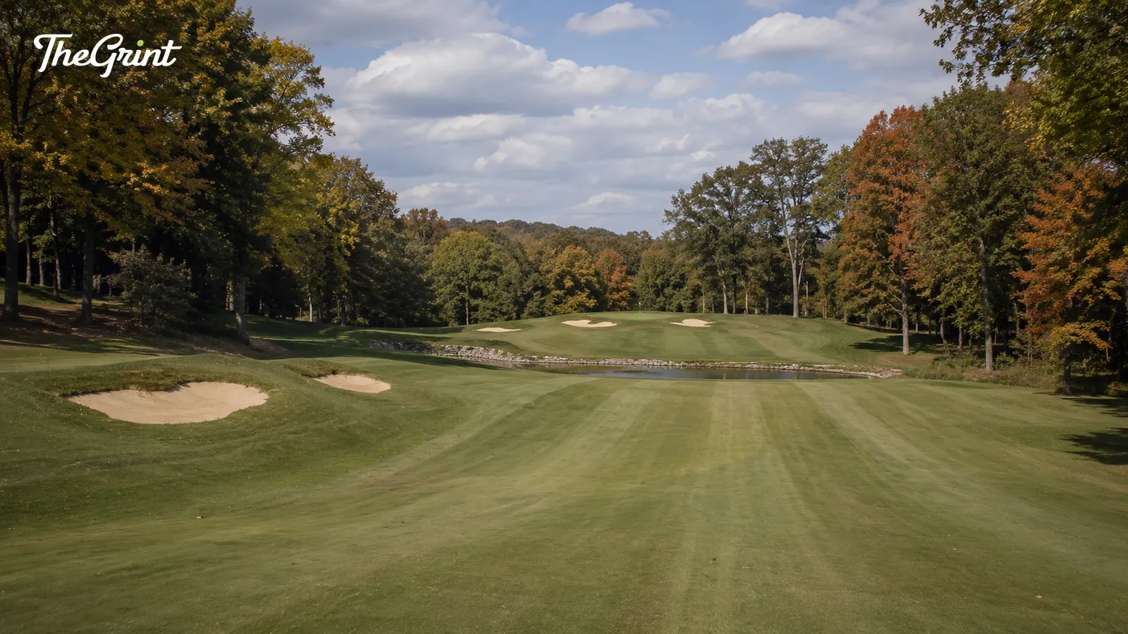 Parkland golf hole with autumn trees, bunkers and a pond in front of the green