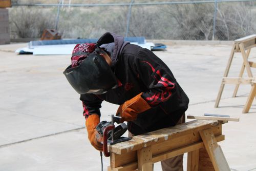 Image of welding student cutting.