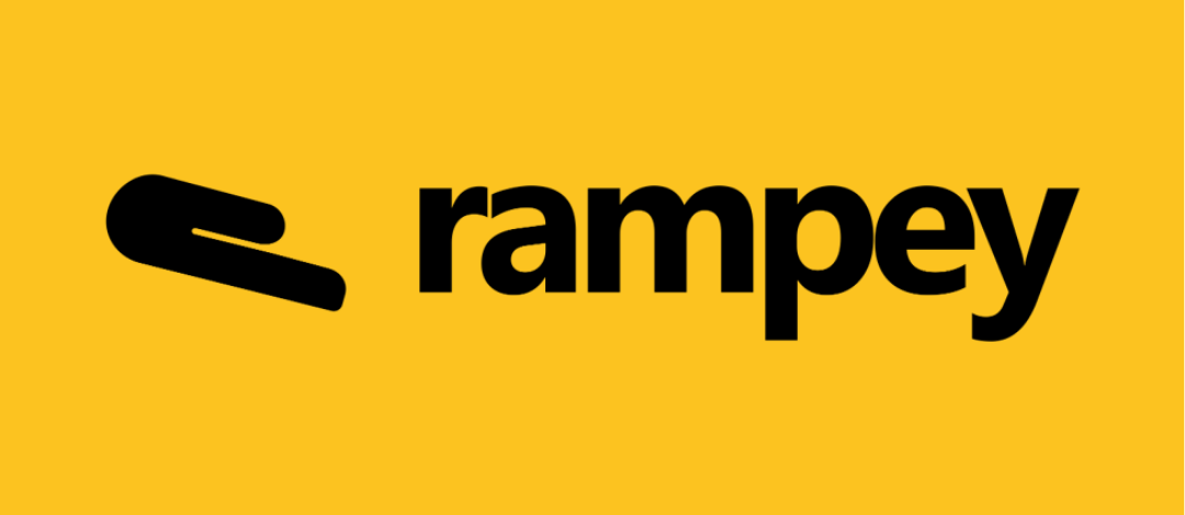 Rampey logo on a yellow background. On the left is a black icon shaped like a hand angled downward, symbolising a ramp or a helping hand. To the right, the word "rampey" is written in bold black lowercase letters.