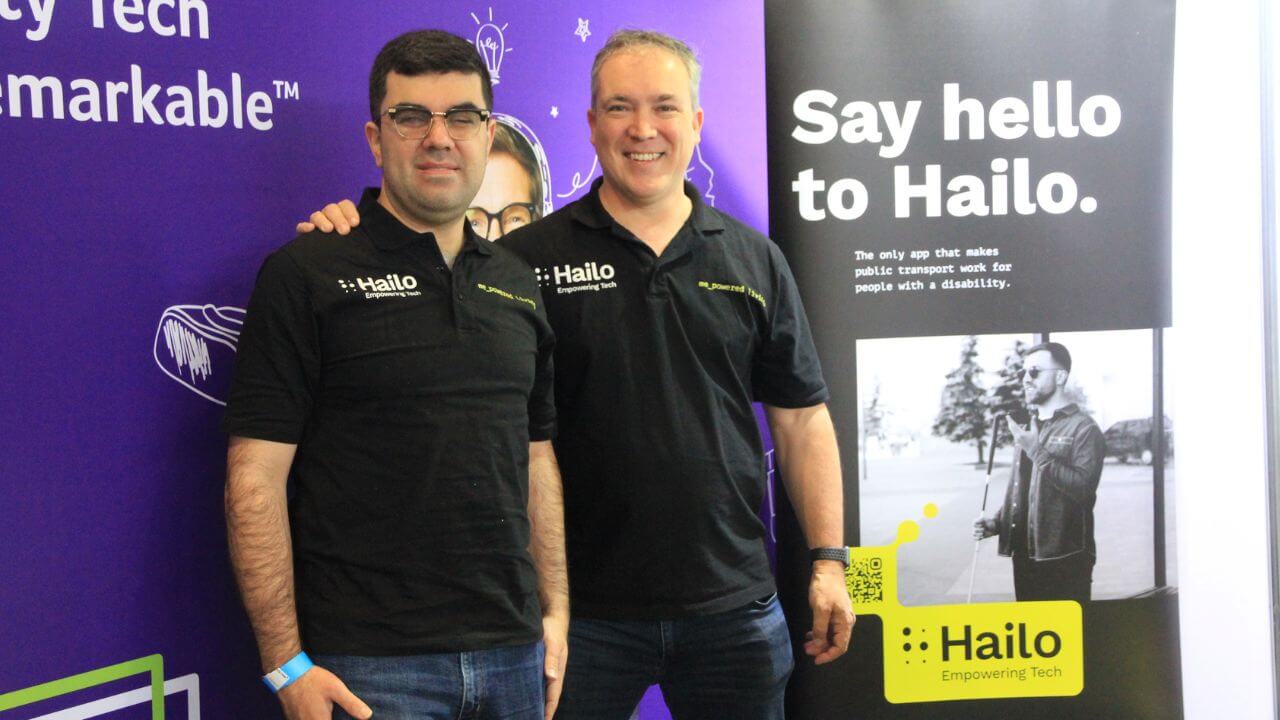 Hailo co-founders together at the Sydney Disability Expo 2025, standing in front of their banner that reads "Say hello to Hailo," showcasing their accessible public transport app.