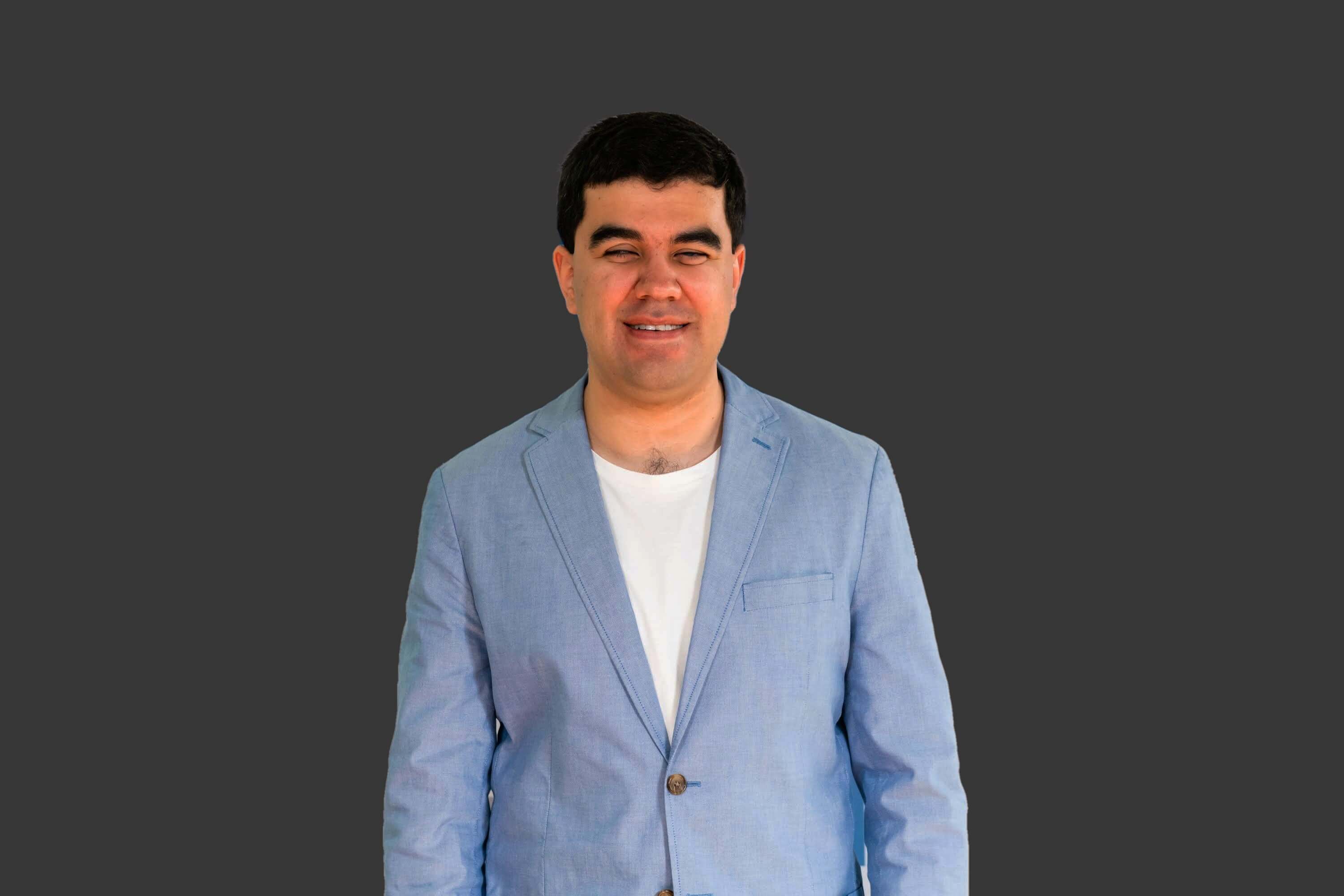 Headshot of Santiago Velasquez looking directly at the camera and he is wearing a business jacket