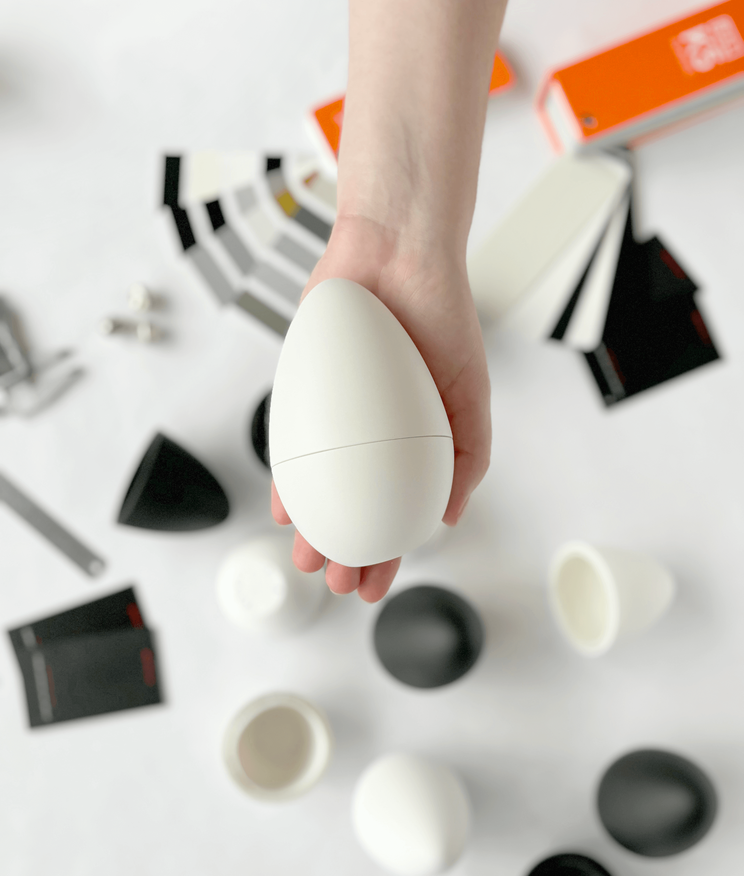 Top view of the EurekIA product prototype surrounded by packaging studies and industrial design components