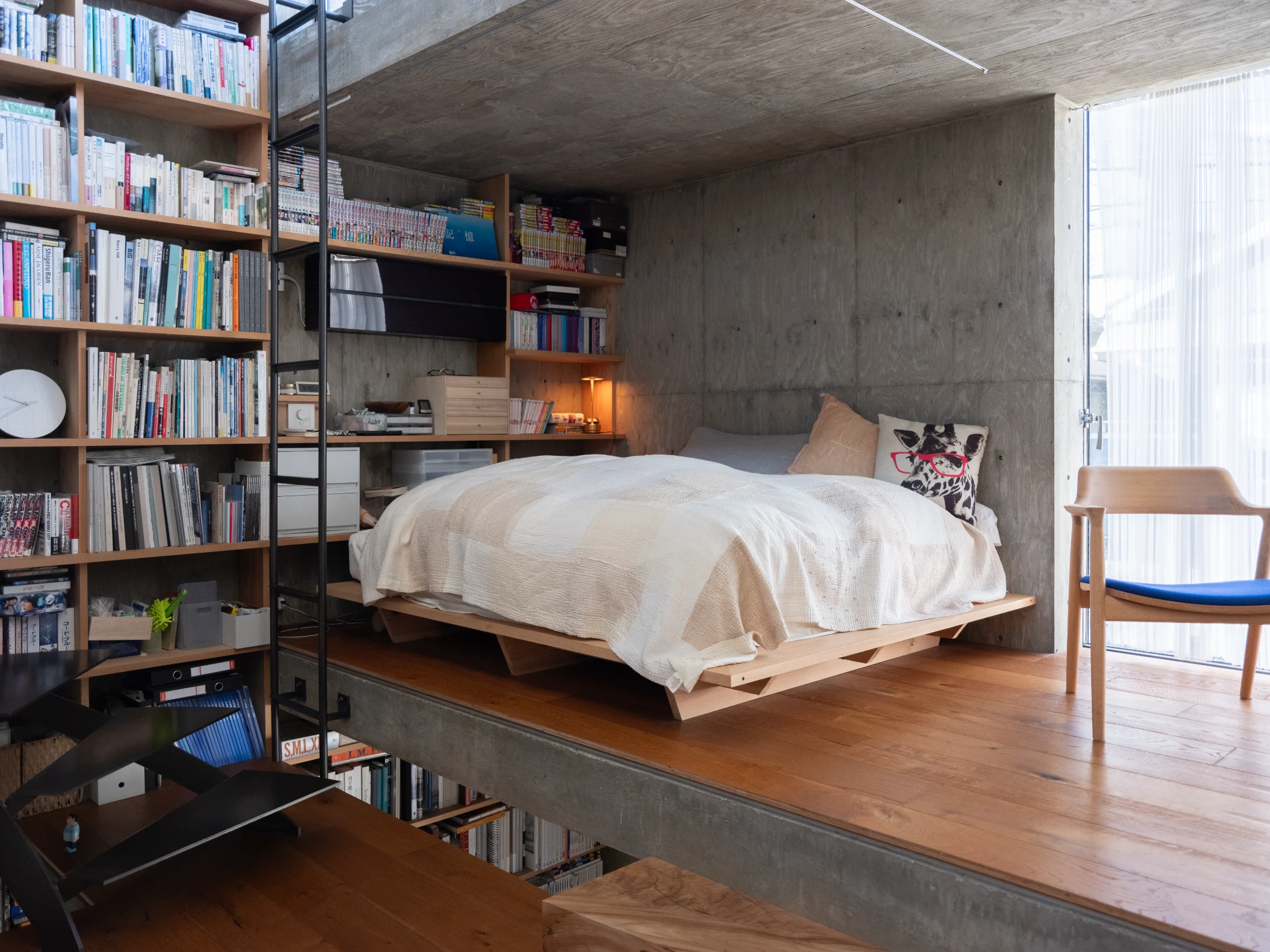 The custom timber bed frame was designed by Masato. The ladder at the foot of the bed leads to the home's roof terrace.