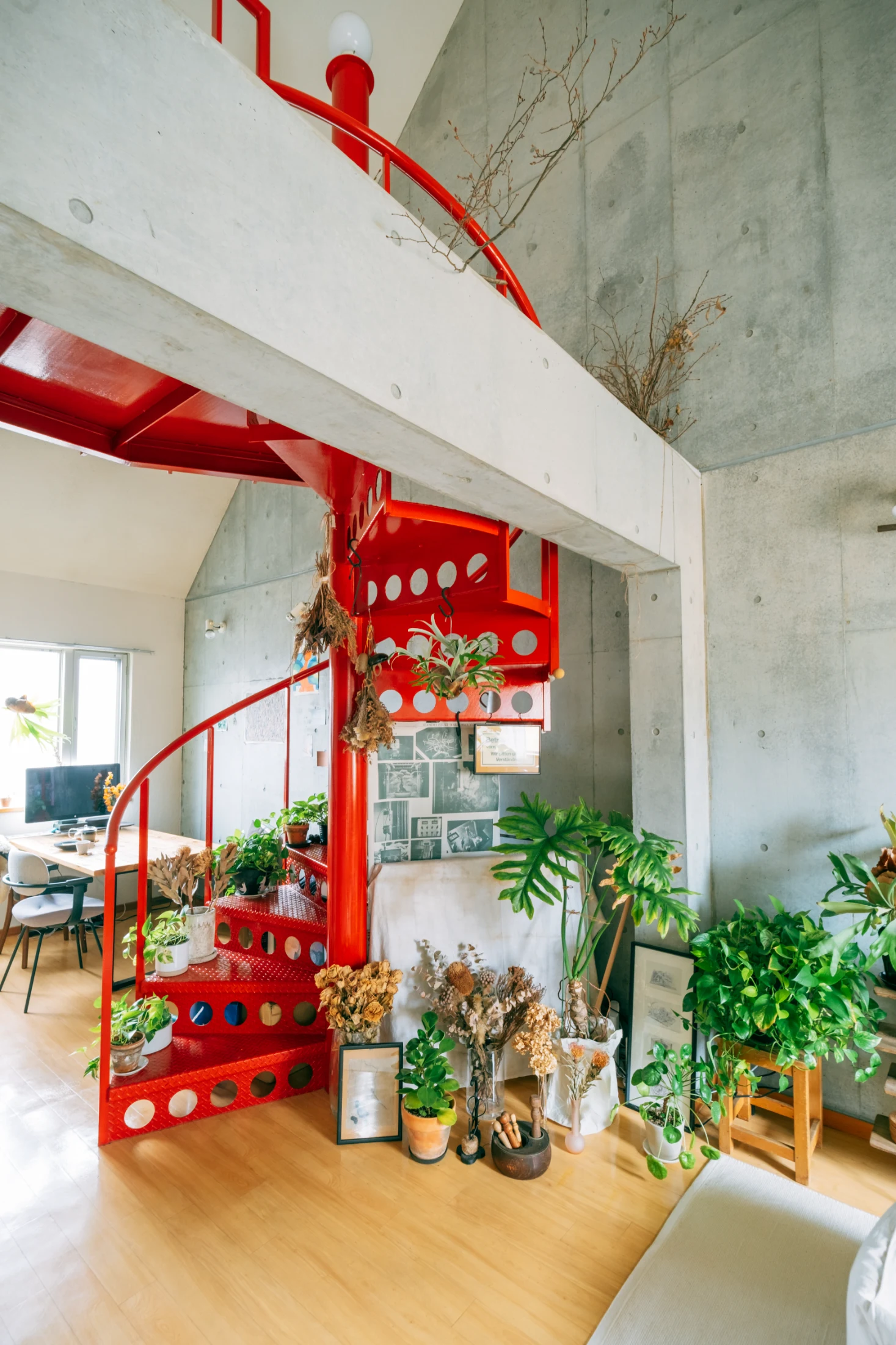 Back in Aya and Sho's rental, an eclectic variety of vessels adds extra interest to their thriving collection of plants. A mixture of hanging plants, petite potted plants, dried flowers and foliage also turns their staircase into a focal point almost akin to an artwork. Image: Tsubottle for Roomie.jp.
