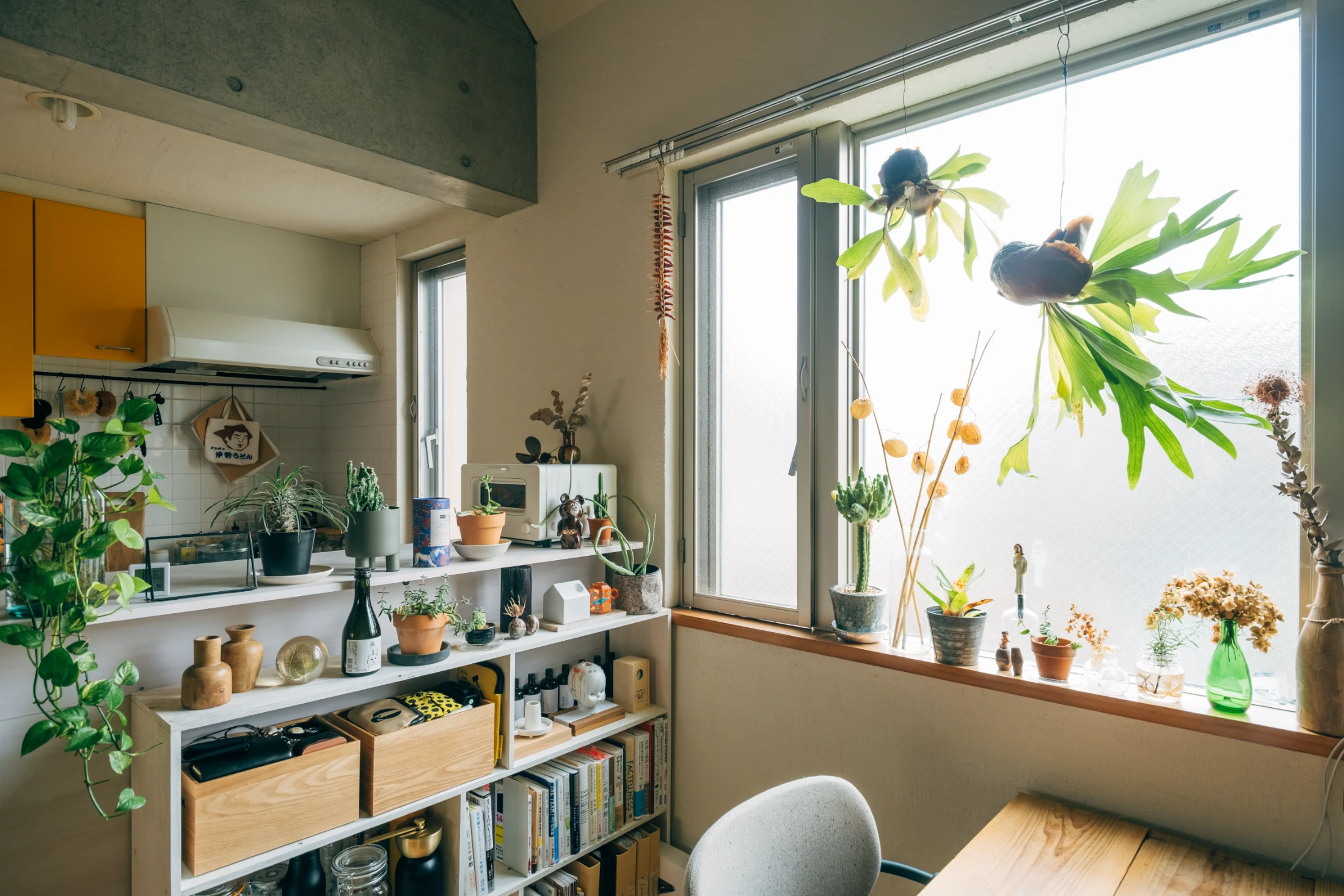 (ABOVE) The kitchen and dining area in Aya and Sho's Tokyo apartment is probably borderline for some but the clusters and connections between objects keep things feeling curated rather than cluttered. Image: Tsubottle for Roomie.jp.