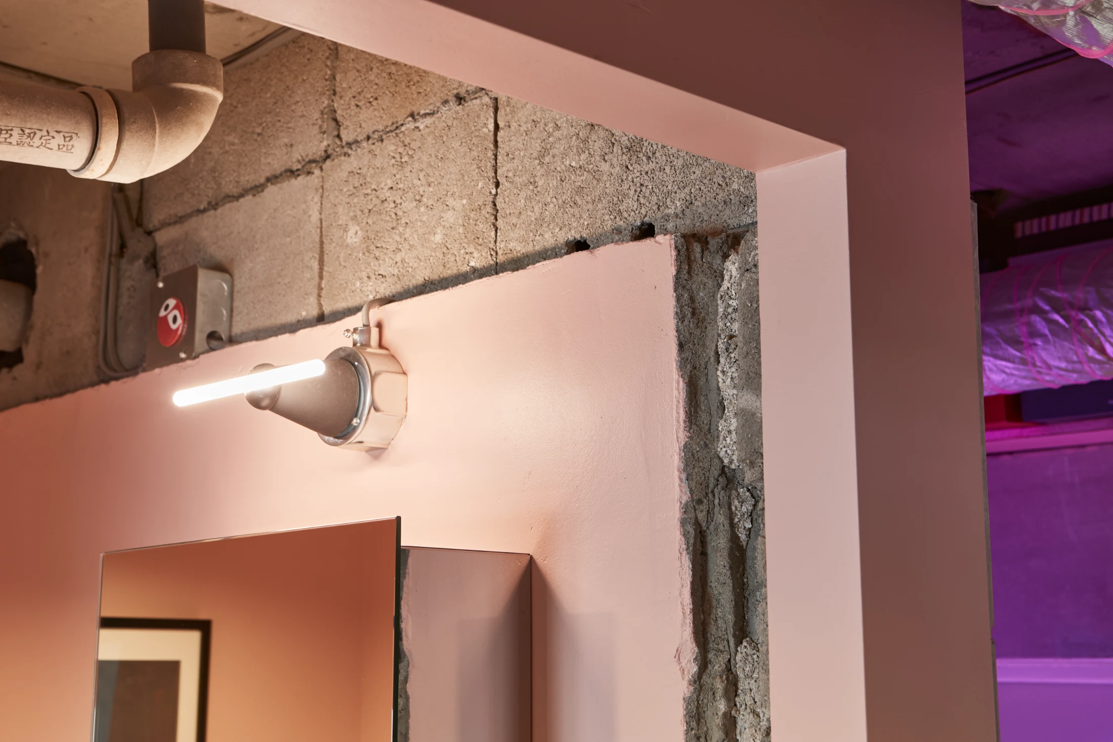 (BELOW) The working structure of a building is part of its story for David and Koichi, the residents of Tokyo Blue, and when they removed all internal walls in their apartment, they delighted in peeling back the layers and finding interesting ways to highlight the character they found. Rough unfinished edges are contrasted here with soft pink painted surfaces. Image: Akira Nakamura and design Kei Makito for Roovice.