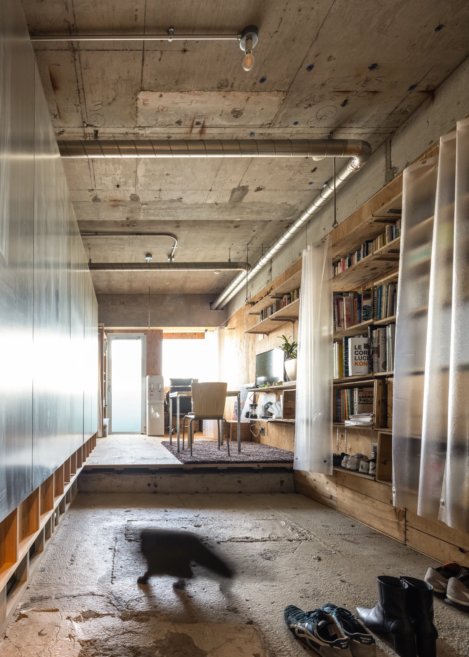 (LEFT) Exposed concrete meets buffed steel, plywood and translucent curtains in the Tokyo home of architect Yutarou Ohta – C/steel Apartment. Image: Masaki Hamada.