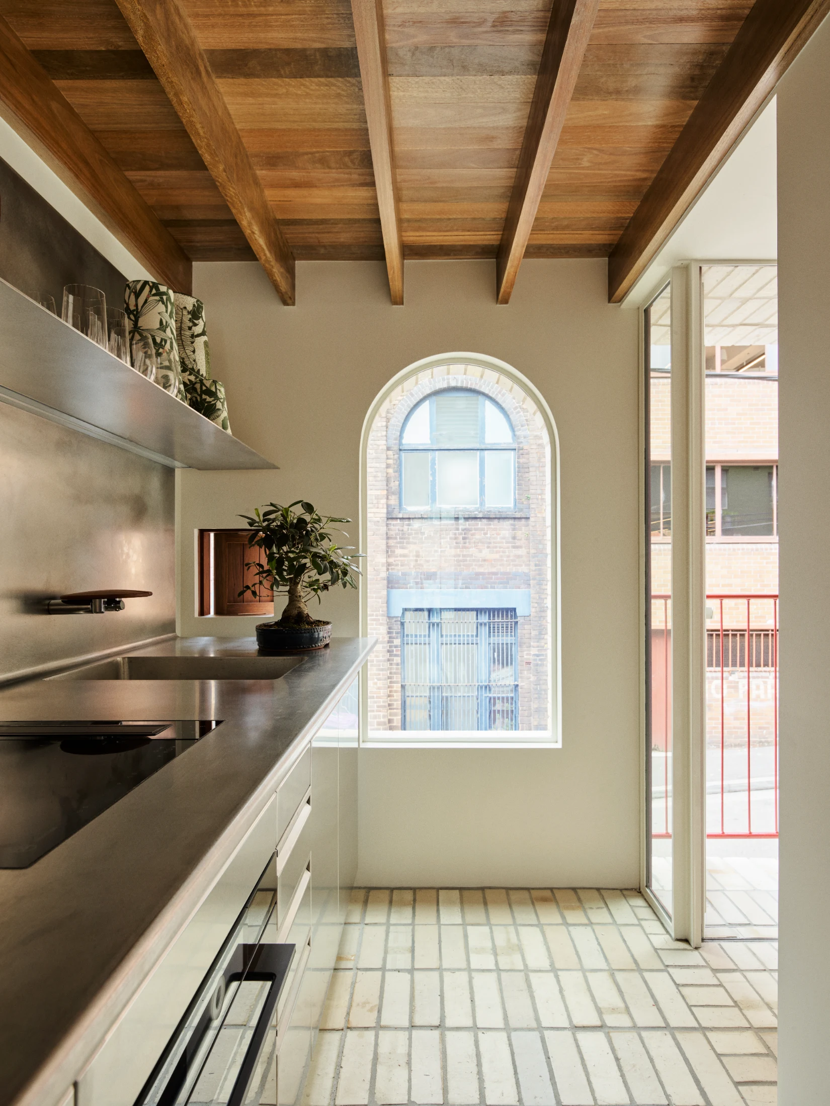 A generous arched window artfully frames and echoes the shape of the arched window across the street.