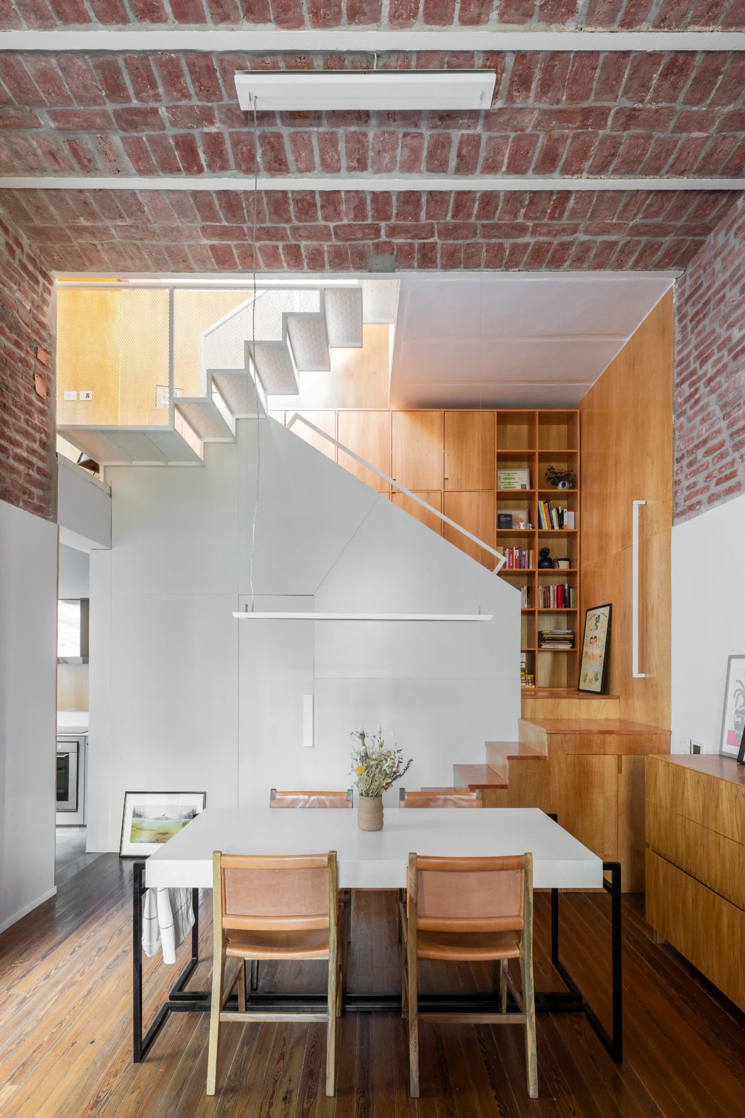 The staircase houses the bathroom and storage and leads up to the home's two bedrooms.