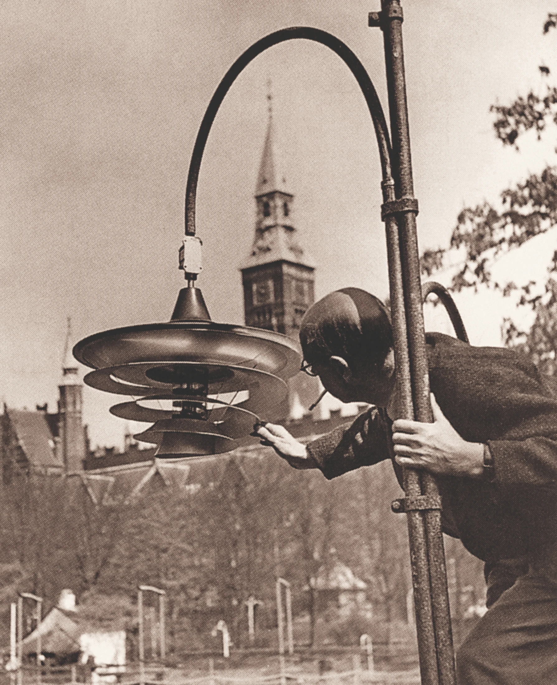 Poul Henningsen inspecting one of his rotating lamps in Copenhagen's Tivoli Gardens in 1949. The tower of Copenhagen City Hall is seen in the background. Image: Courtesy and copyright © Louis Poulsen