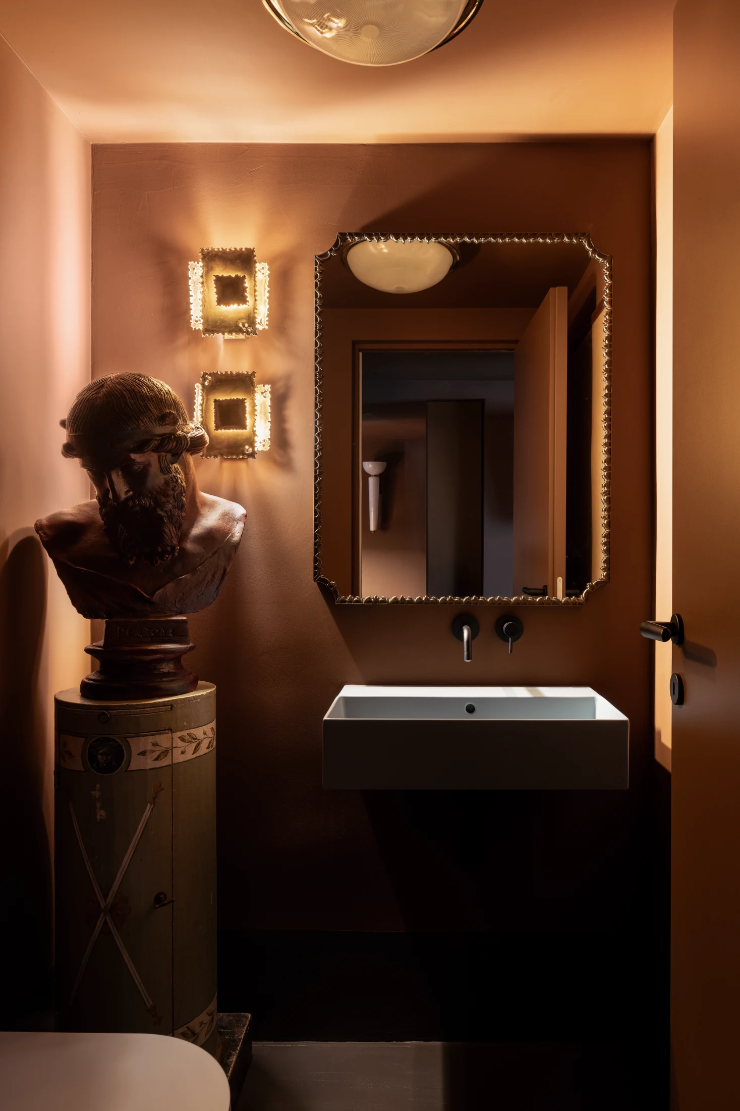 Poerio's brown bathroom features brass brutalist wall lamps by Danish designer Svend Aage Holm Sørensen in the 1960s.