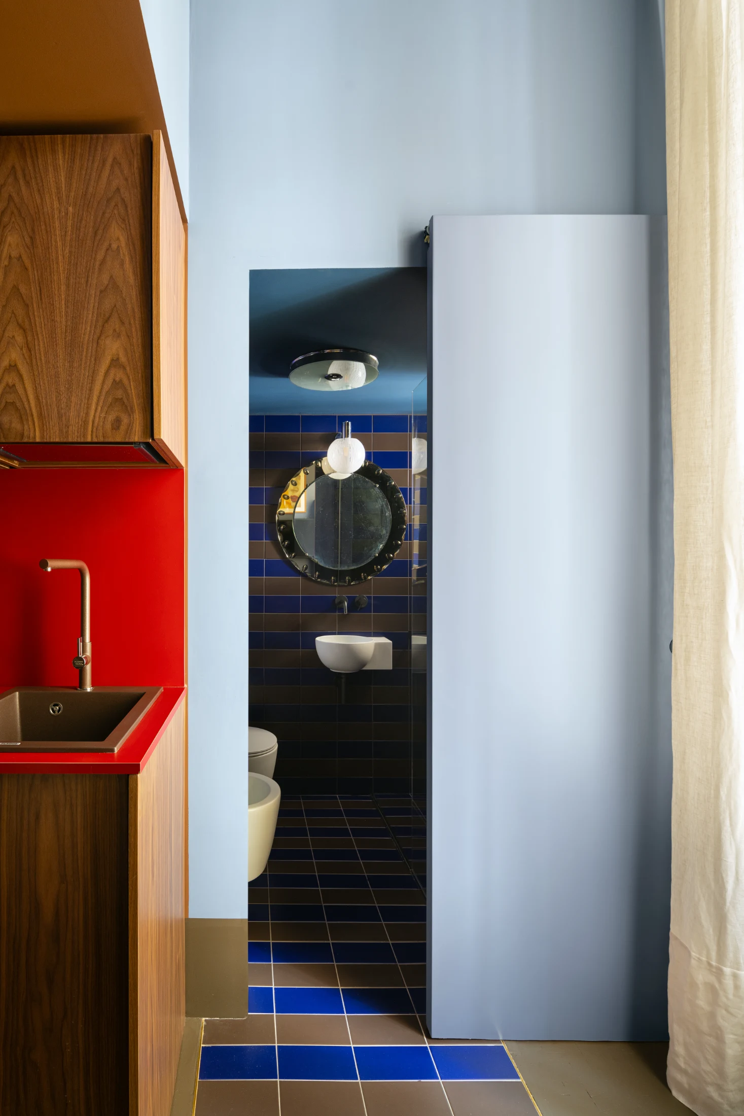 While blues, browns and reds are a common thread throughout the colour scheme, each space has its own distinct palette, including the powder room accessed via a sliding door off the kitchen.