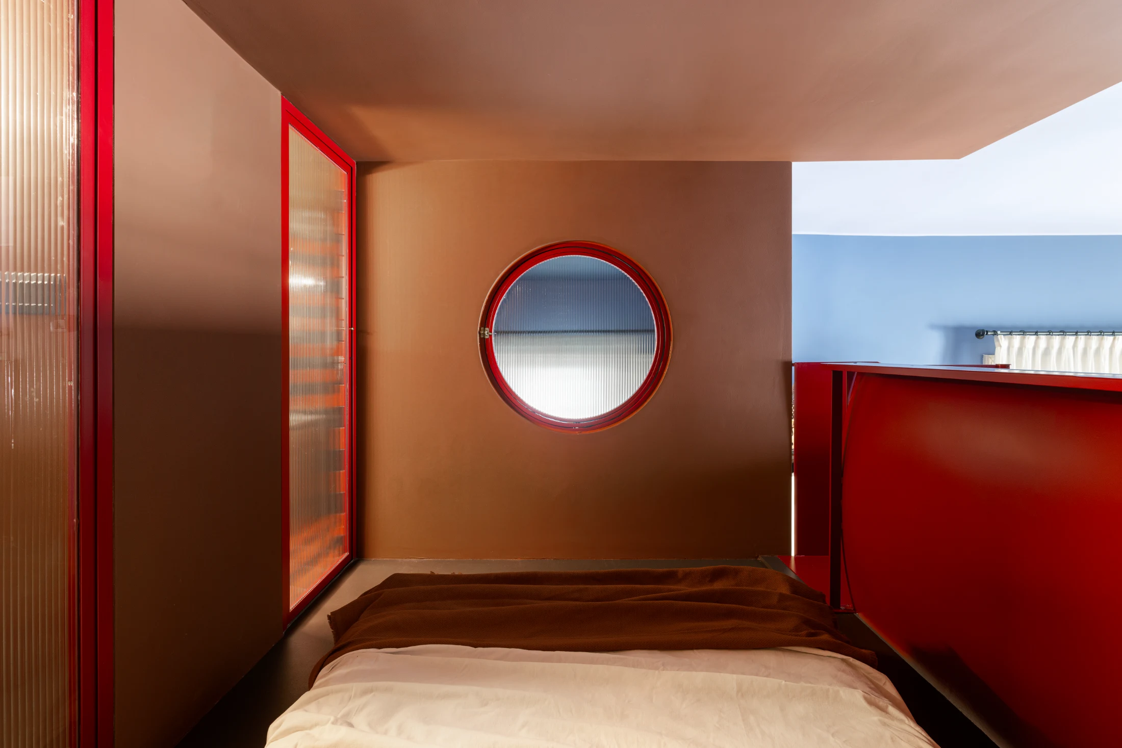 The porthole (one of Julie and Giuseppe's favourite features of Poerio) opens out to connect the bedroom and mezzanine level with the floor below.