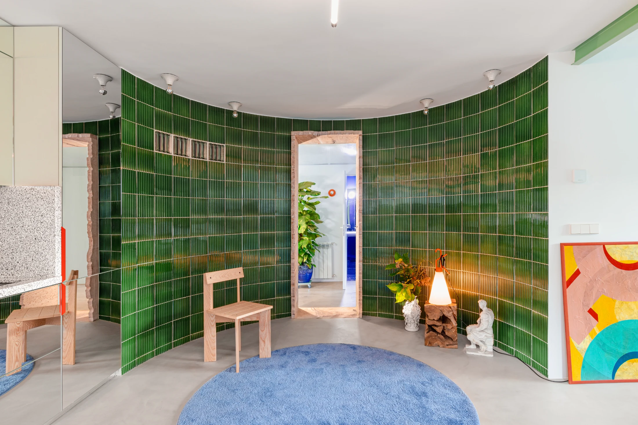 The curved green tiled wall is both the apartment's striking centrepiece and a key feature in breaking the rigid boundaries of the traditional compartmentalised apartment layout. Image: hiperfocal.