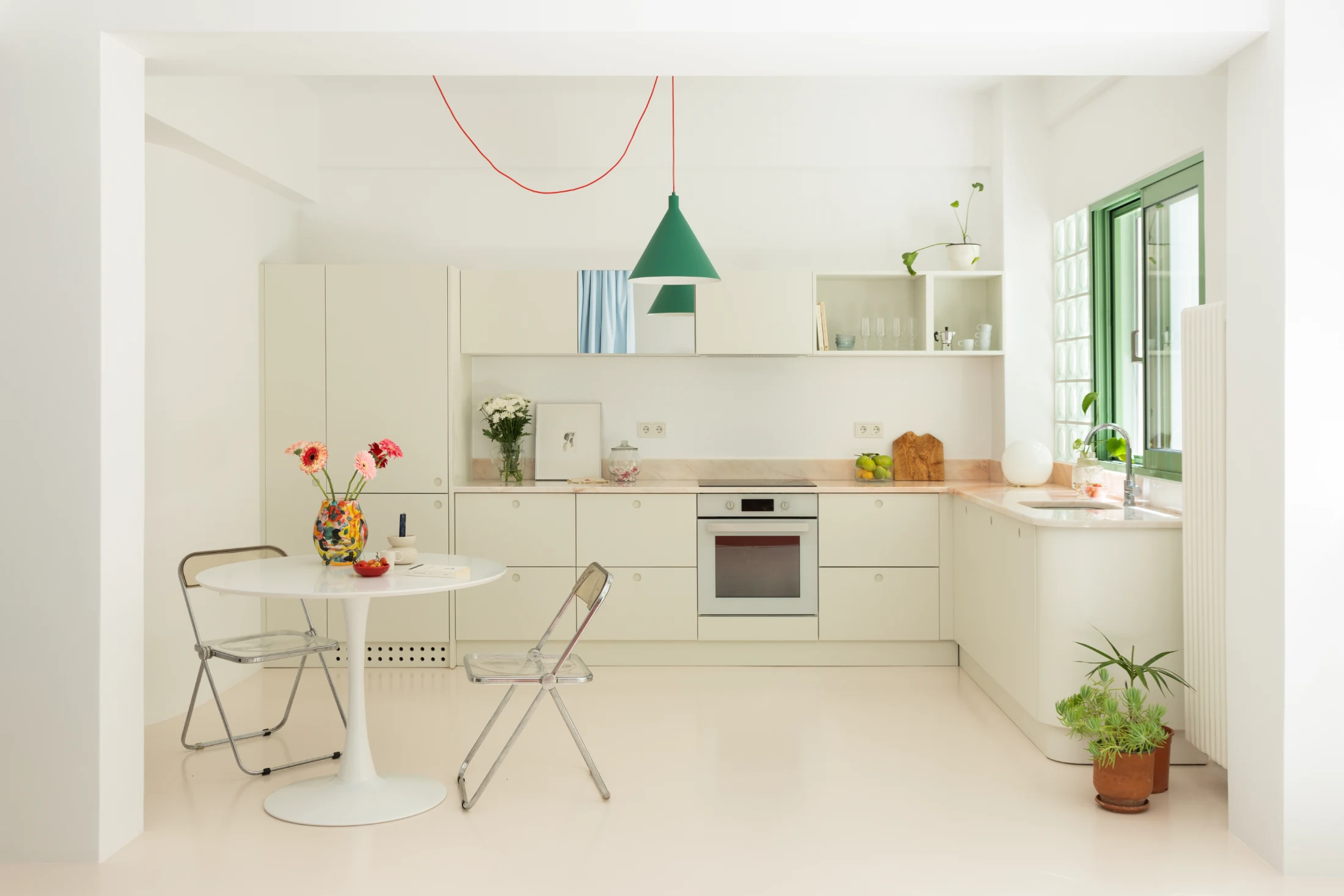 Presenting a fully equipped kitchen in an aesthetically pleasing way is achieved with the help of mirrored cabinet doors and a calm colour palette.