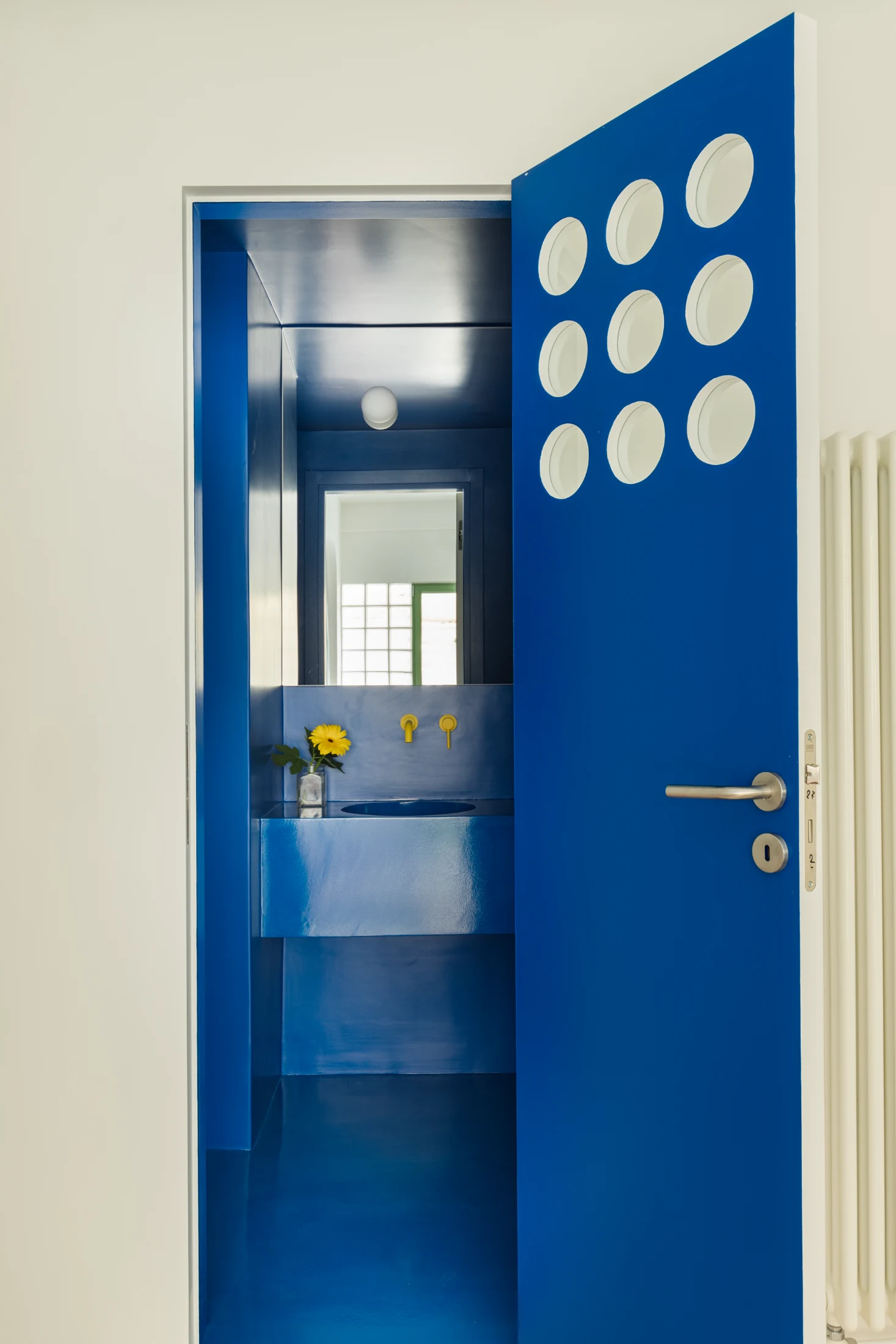 Embracing the lack of a natural light source, the bathroom was designed to be an