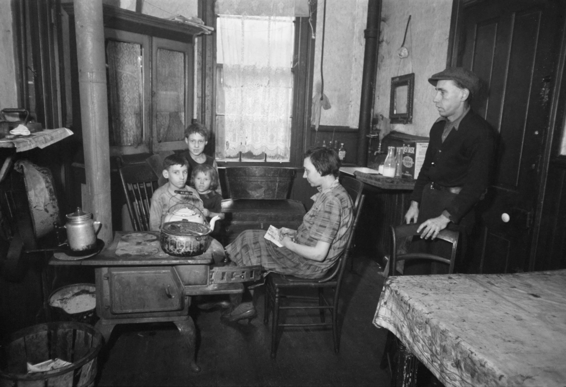 A family in their tenement kitchen, Hamilton Co, Ohio, Dec 1935. Image: Carl Mydans / Alamy Stock Photo.