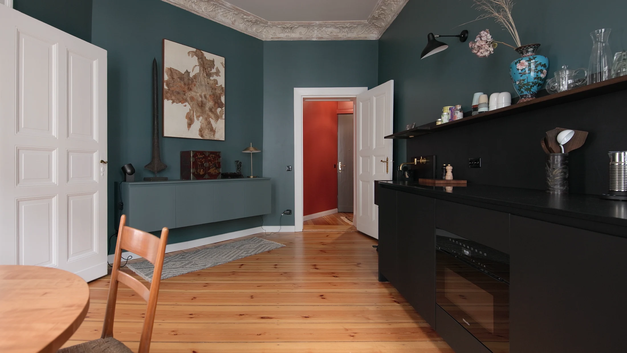 Designed by Dax 1, Kloedenstraße's floating sideboard may look like an unassuming piece of furniture. Painted the same 'Inchyra Blue' shade as the apartment's walls, this wall-mounted sideboard is in fact the kitchen's main source of storage with crockery