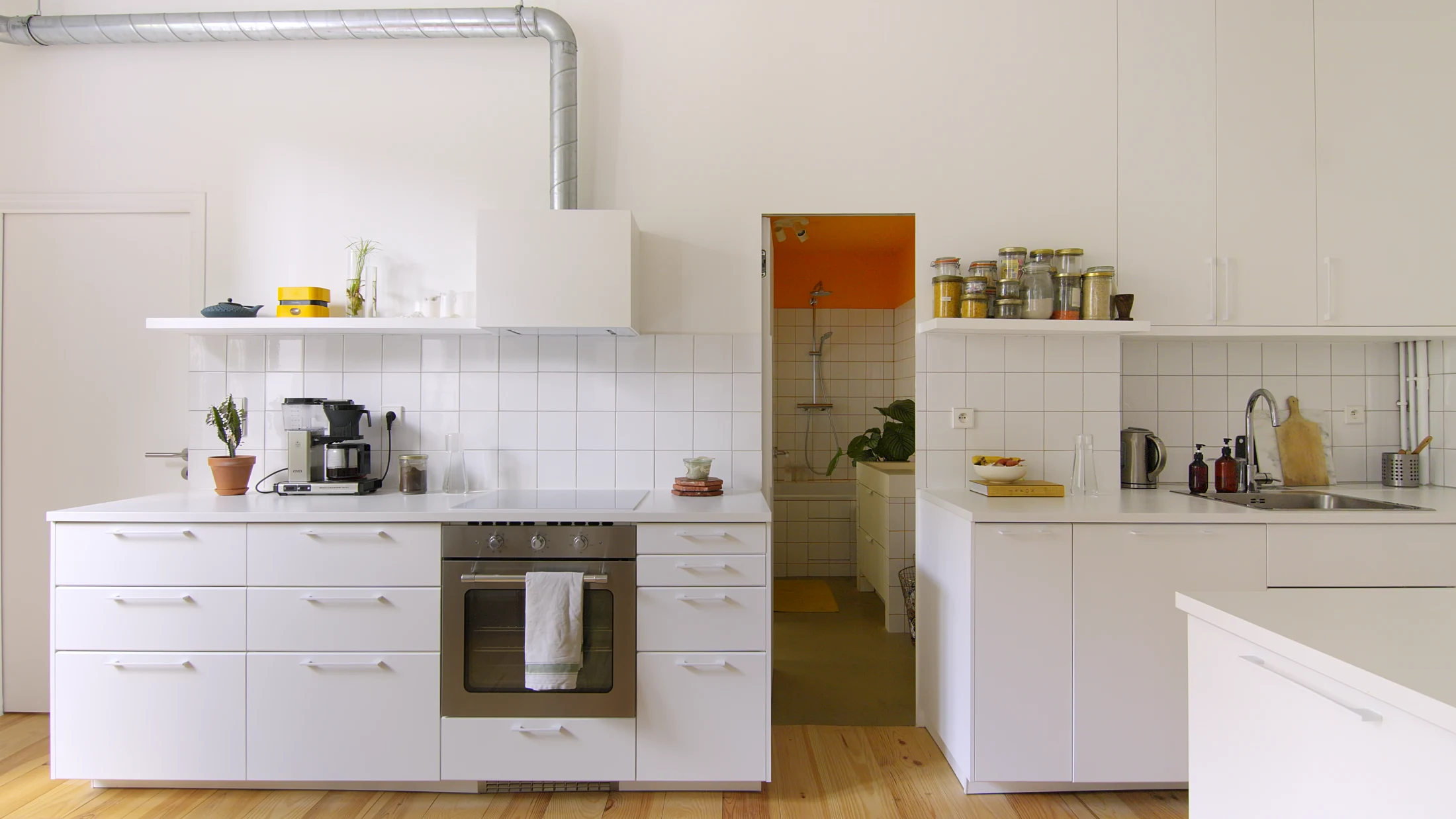 In Appartement Rue de Nantes designed by PS Studio, a section of the single-wall kitchen is mounted on small wheels and can be detached to reveal a cleverly camouflaged concealed door that provides access to the ensuite bathroom for guests. To maximise fun