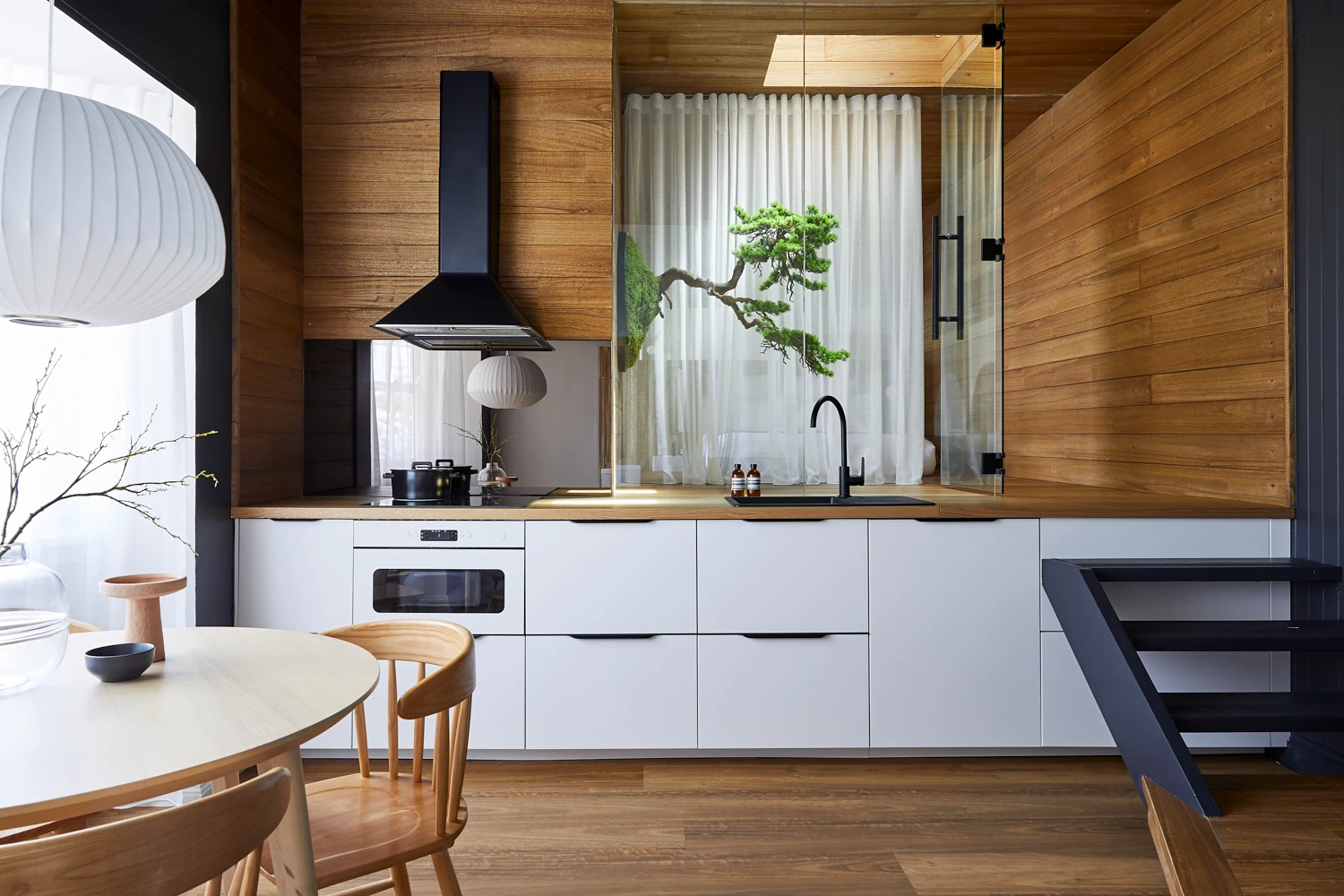 A combination of natural light filling the apartment and an abundance of mirrors make for a light-filled, open kitchen, living and dining space with a softer ambient reflection in Dforn Projects' Ryokan Project.