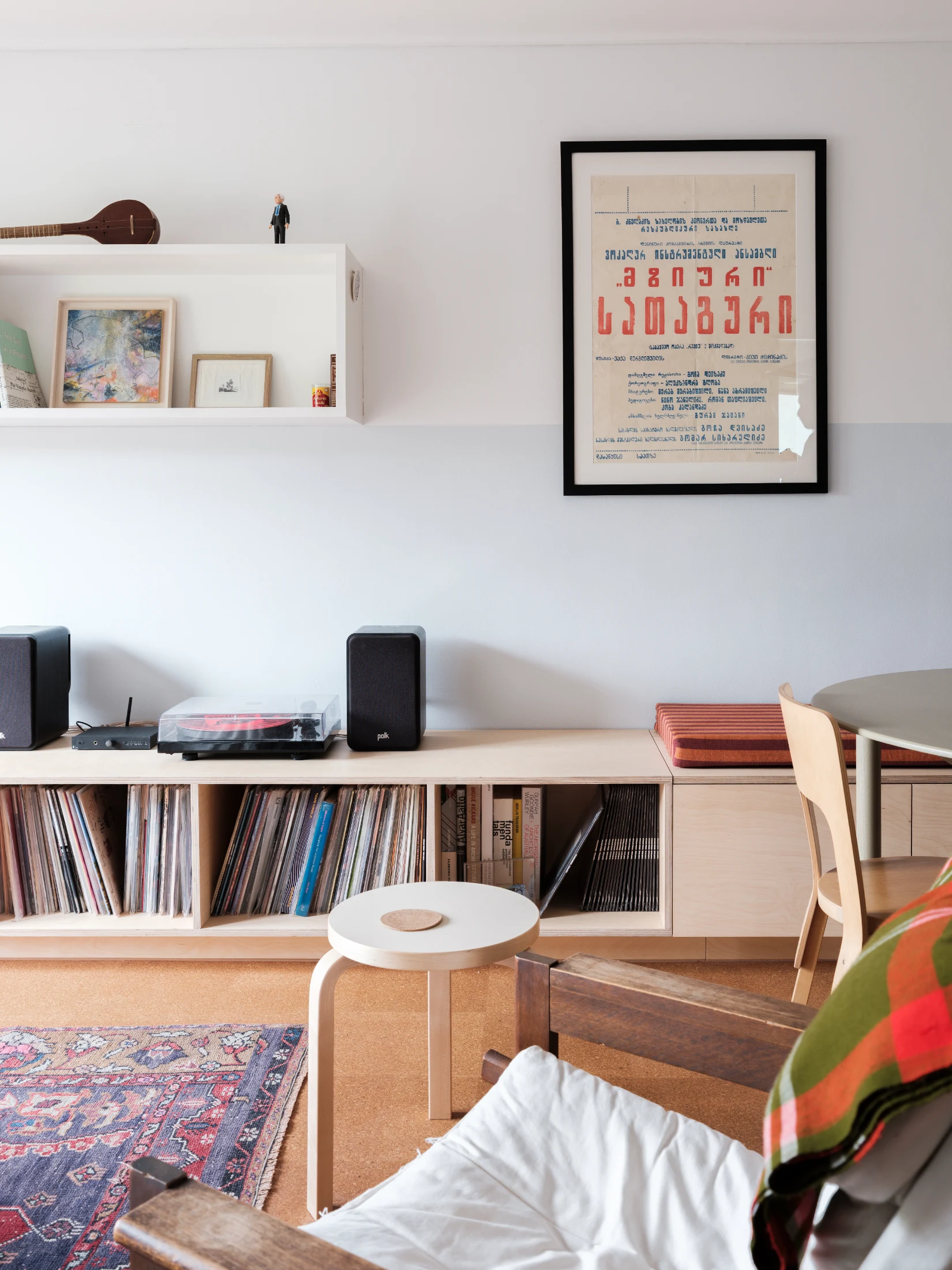 Running the length of the dining and living space, the multifunctional plywood built-in unit serves both as the dining area's bench seat and a storage cabinet.