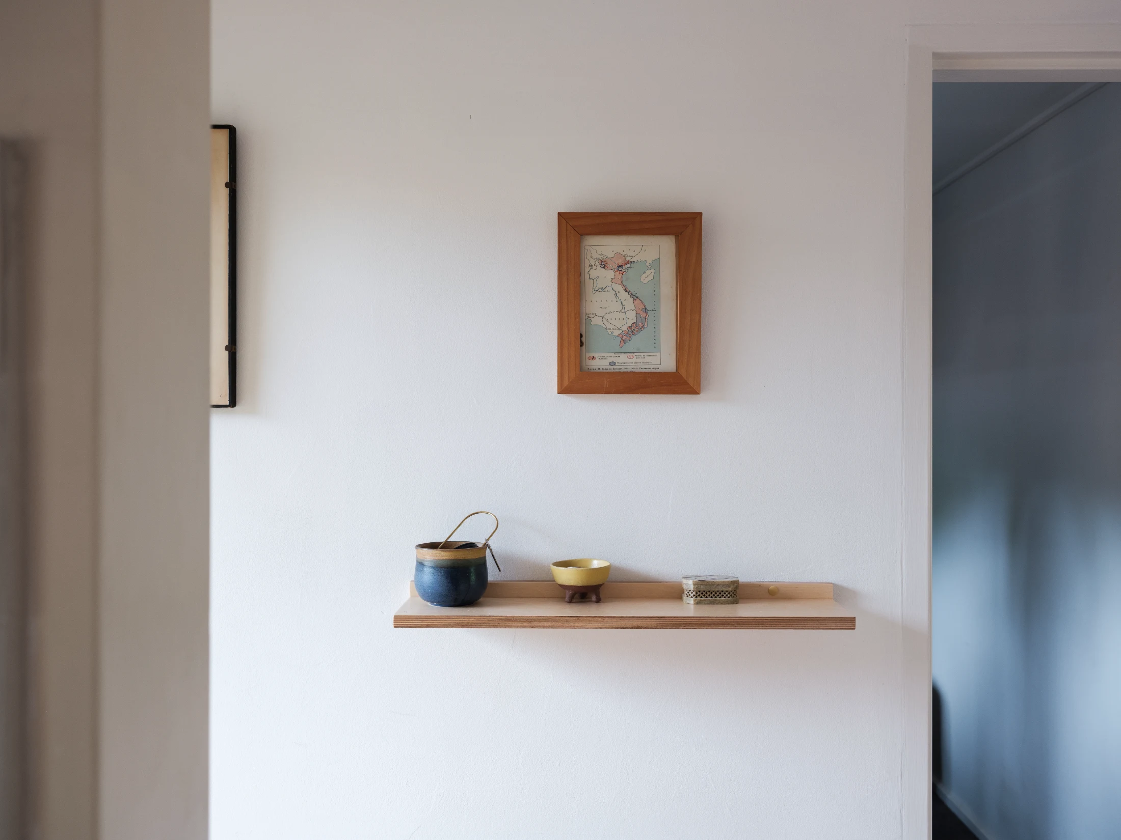 A simple wall-mounted shelf allows collections of keepsakes and momentos to be on show and add character to the apartment.